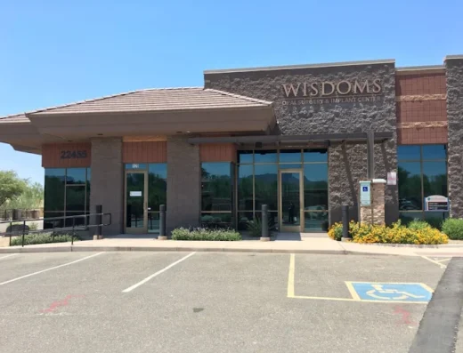 Front view of Wisdoms Oral Surgery & Implant Center, a brick storefront with glass doors and landscaping; handicap parking in the foreground.